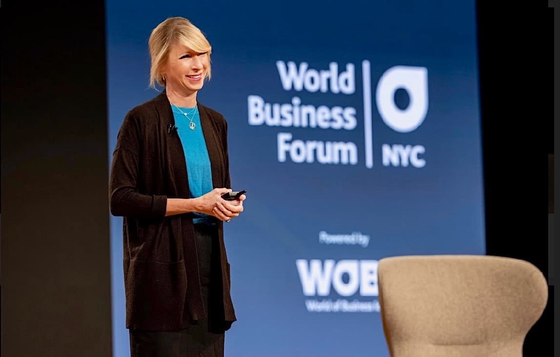 Amy Cuddy smiling on stage at World Business Forum NYC